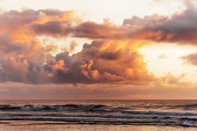 fluffy sunset clouds above waves